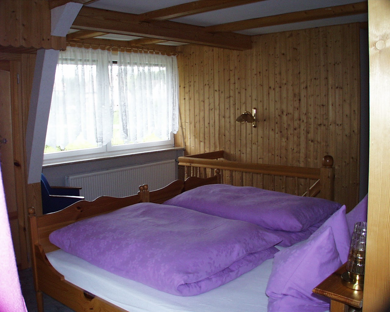 Schlafzimmer mit Doppelbett und Holzvertäfelung