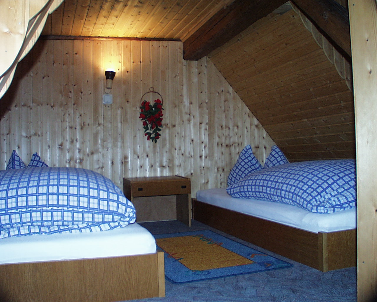 Schlafzimmer mit zwei Einzelbetten unter dem Dachgebälk